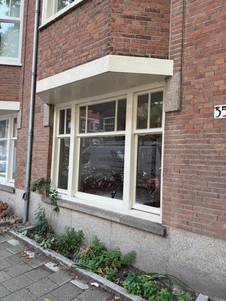 Voorgevel van benedenwoning tijdens project kunststof kozijnen Amsterdam met behoud van klassieke raamverdeling