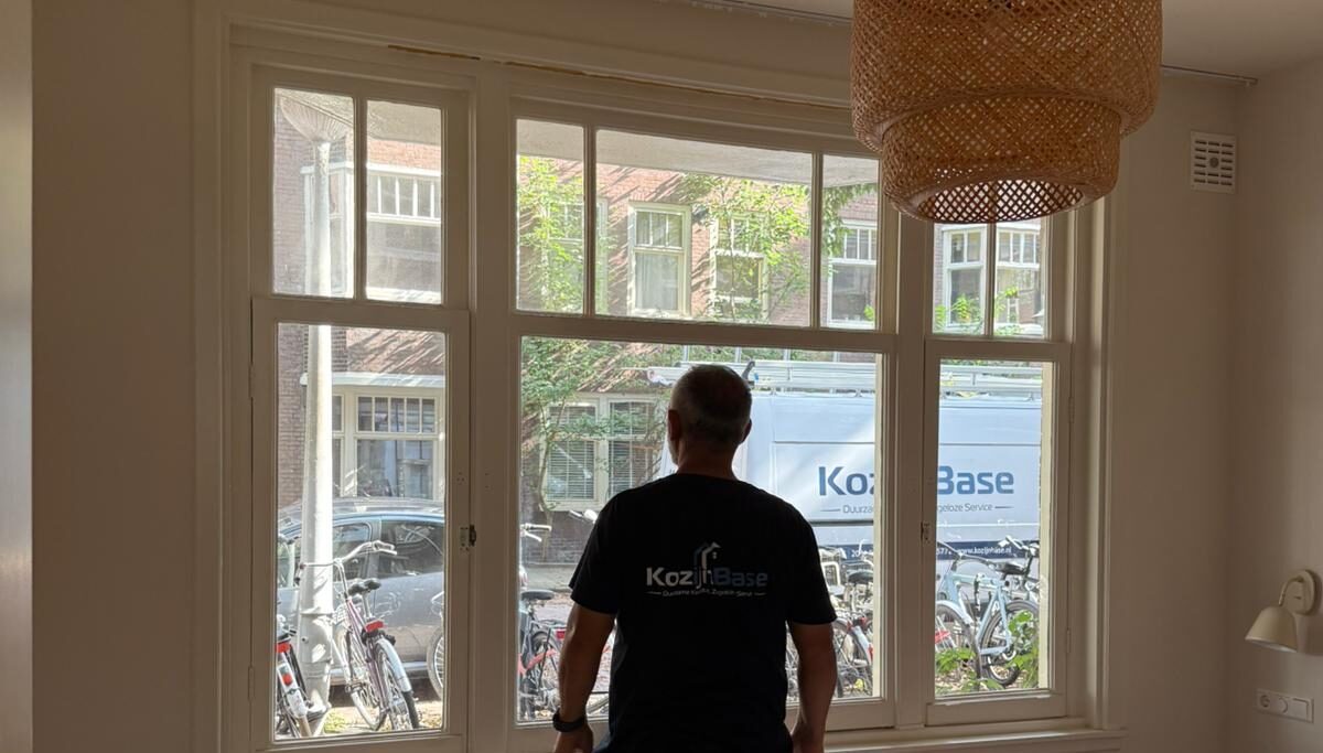 Monteur controleert plaatsing tijdens project kunststof kozijnen Amsterdam met klassieke raamverdeling