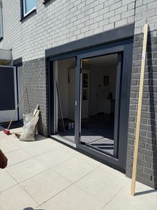 Plaatsen van schuifpui tijdens montagewerkzaamheden