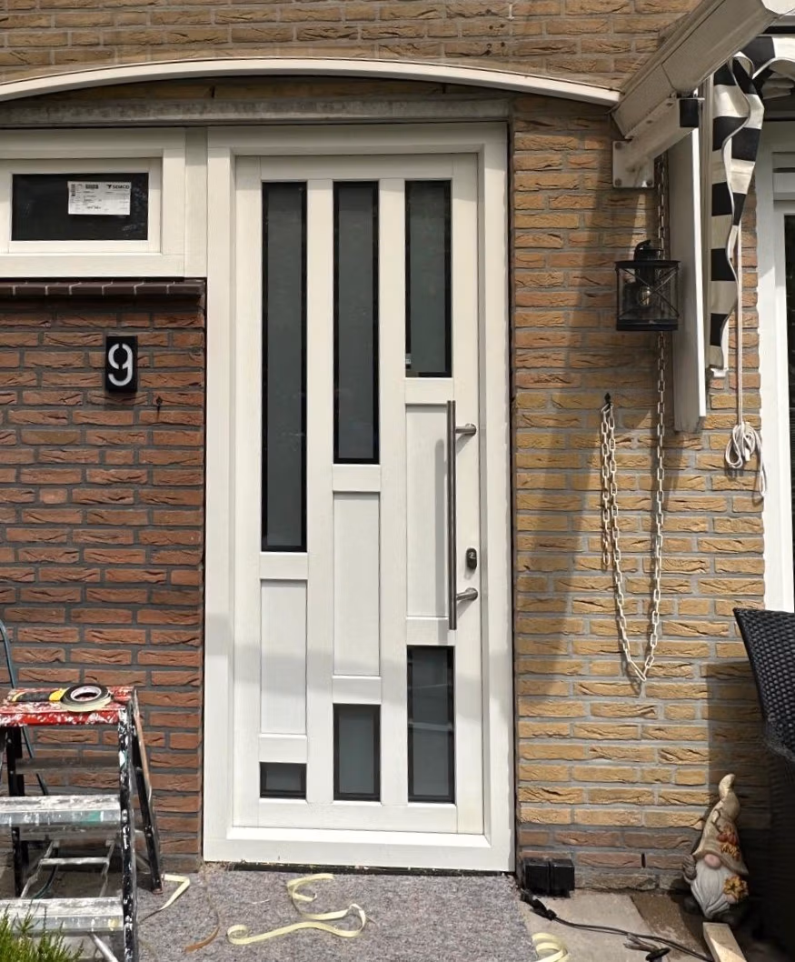 Plaatsen van voordeur in gevel tijdens montage