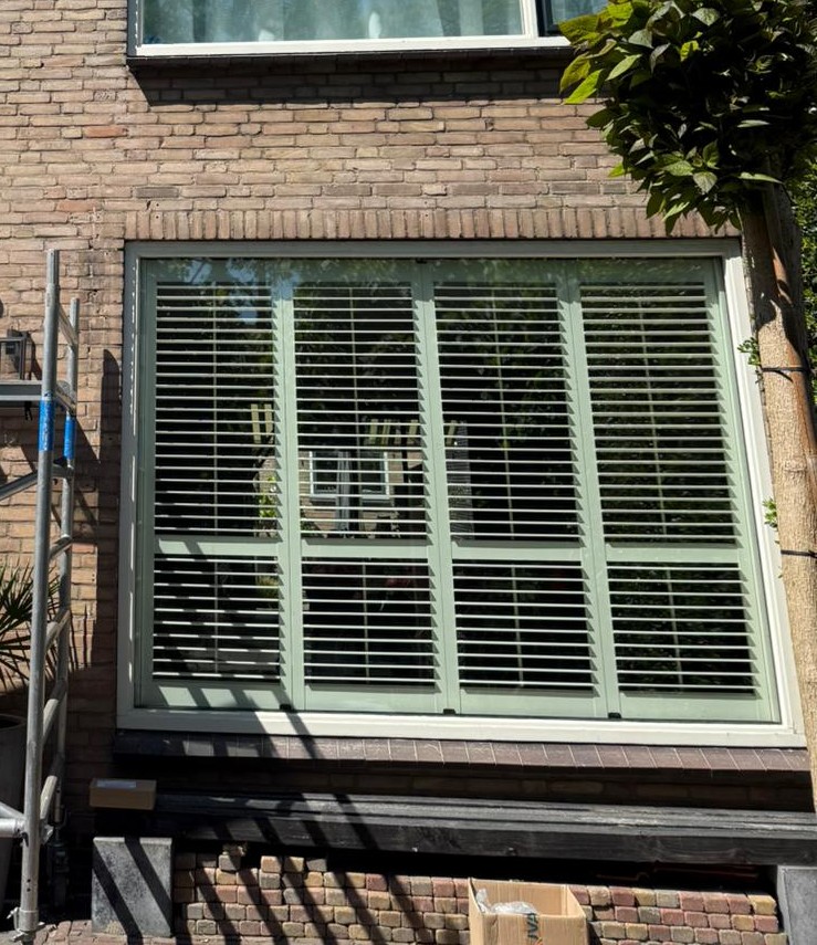 Raam met jaloezie die zonlicht en inkijk regelt in Haarlem