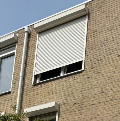 Buitenrolluik dat zonlicht en inkijk bij een raam vermindert