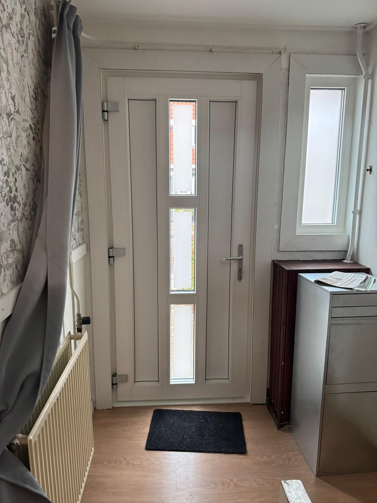 Kunststof voordeur met glas en kozijn aan de binnenzijde, nette afwerking en goede lichtinval