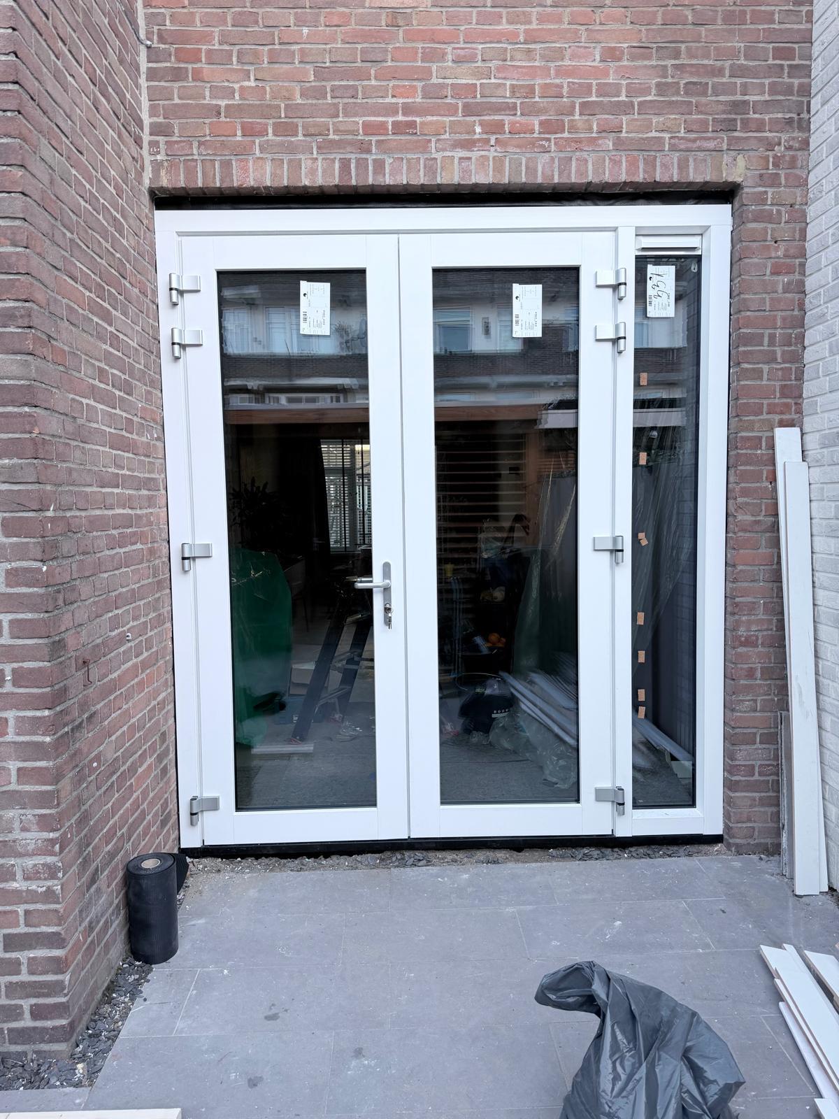 Kunststof openslaande deuren met kozijn en glas geplaatst aan achterzijde woning