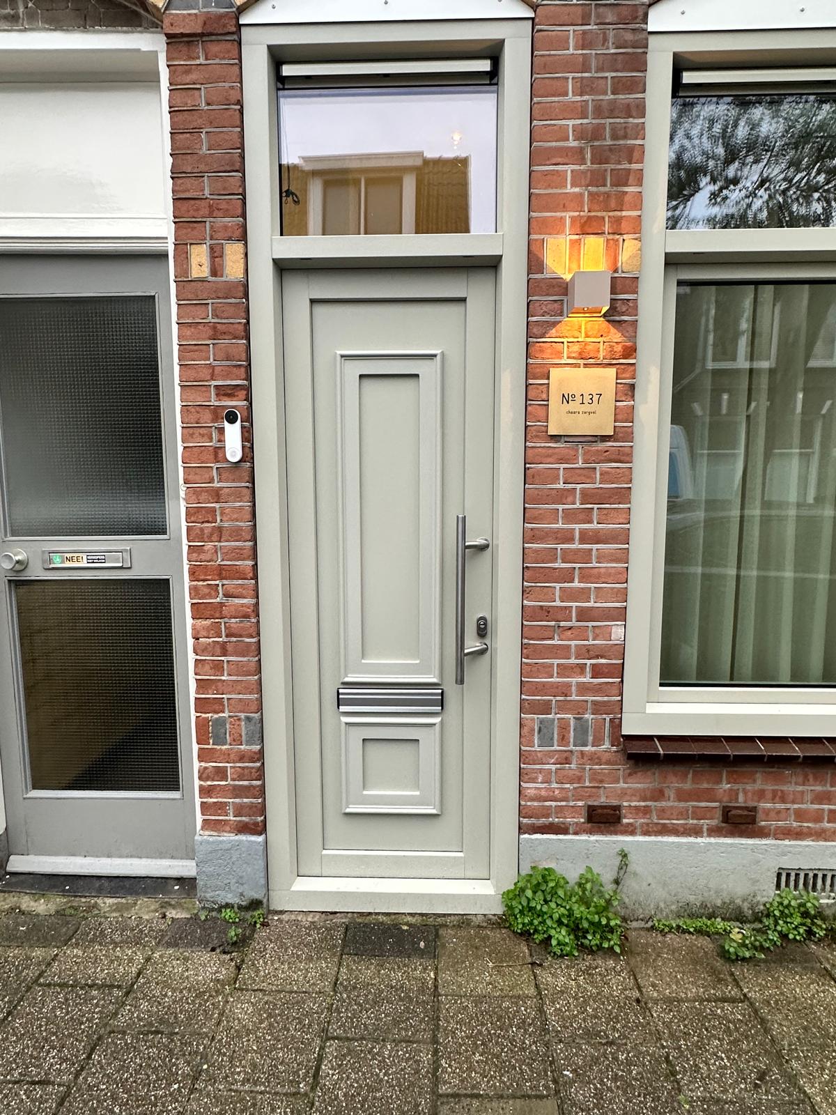 Klassieke kunststof voordeur met kozijn geplaatst in bestaande gevel met strakke afwerking