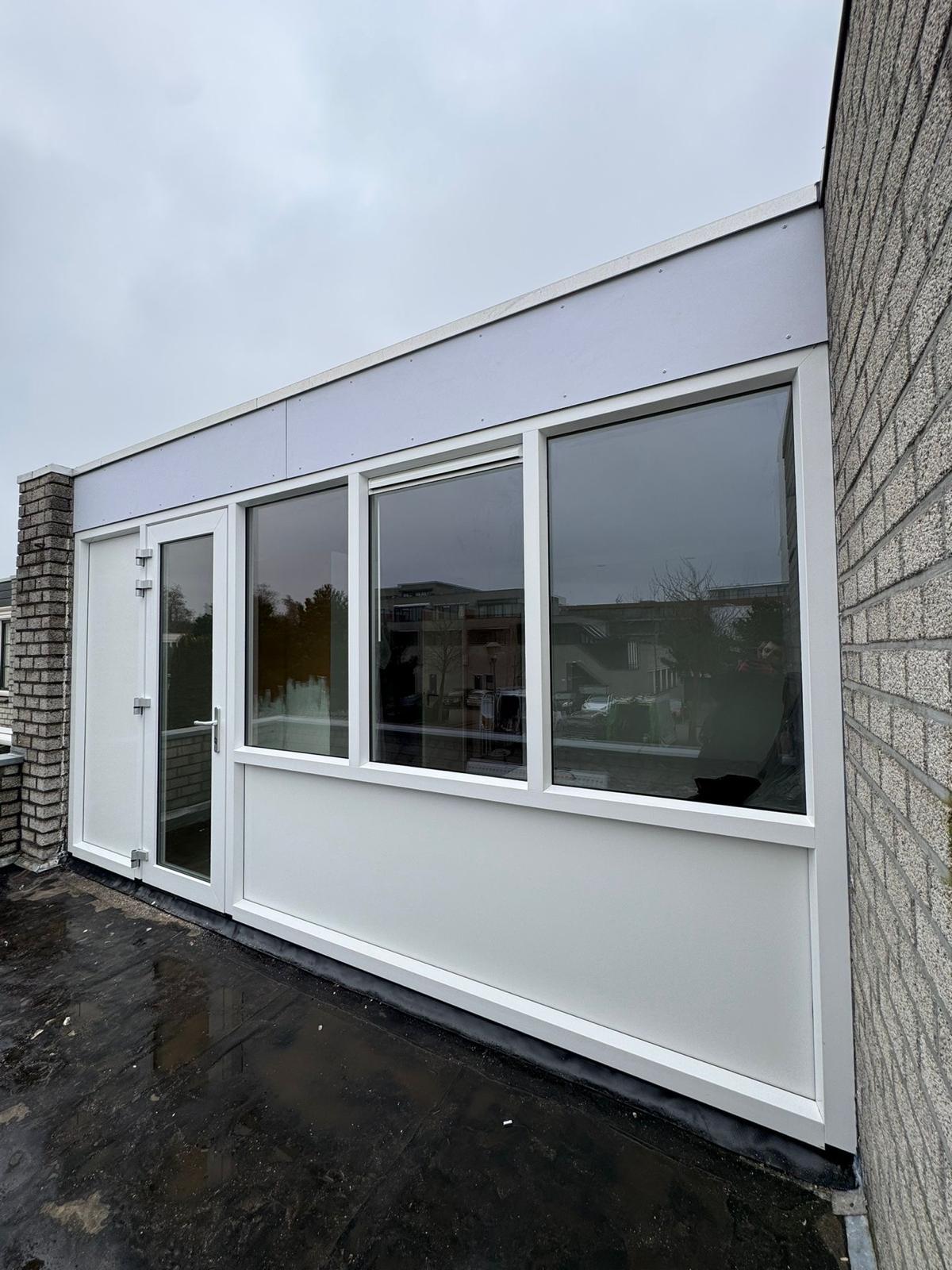 Moderne uitbouw met witte kunststof kozijnen en gevelbekleding