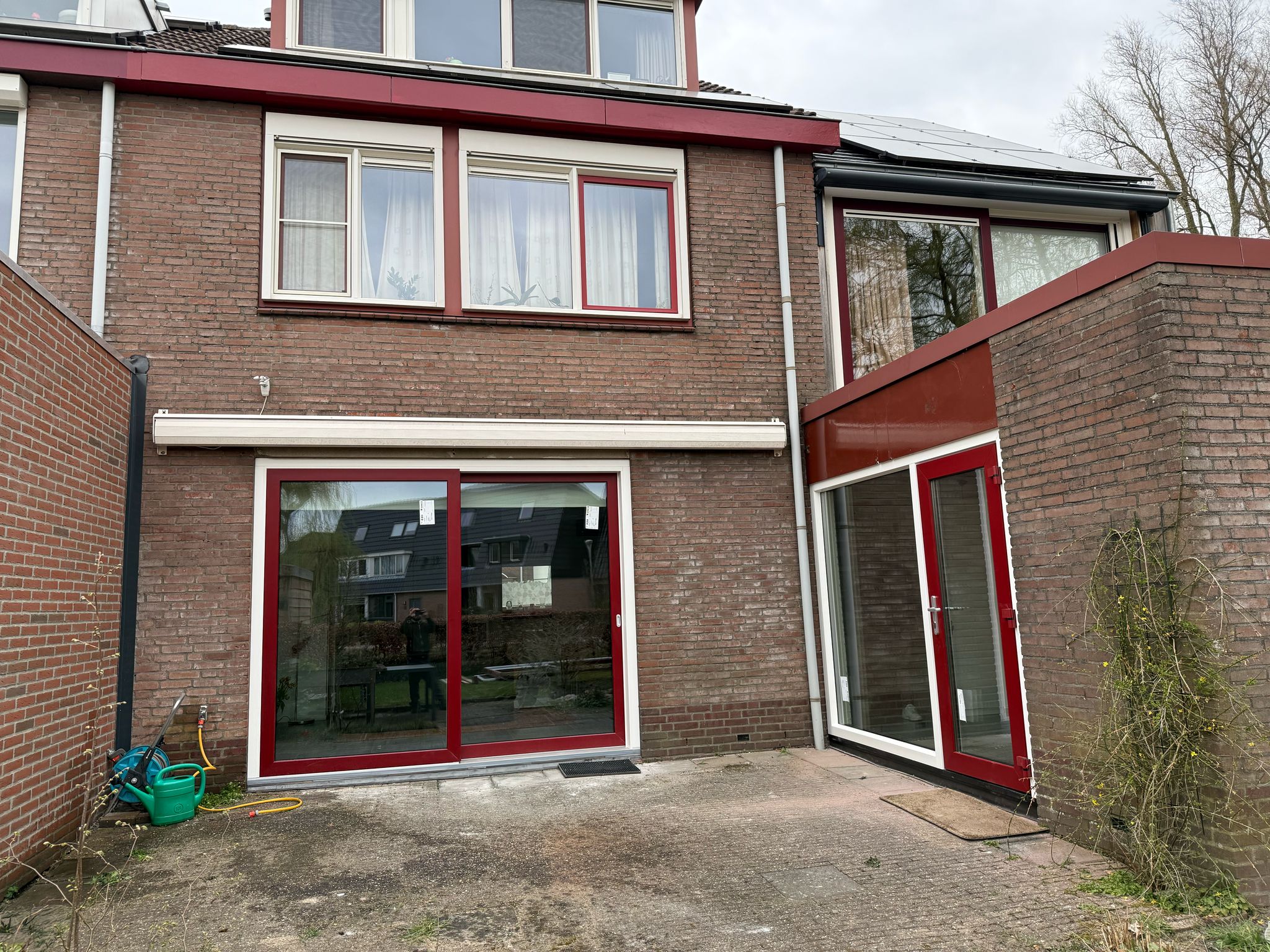 Kozijnen vervangen Halfweg met rode kunststof kozijnen en schuifpui in achtergevel woning