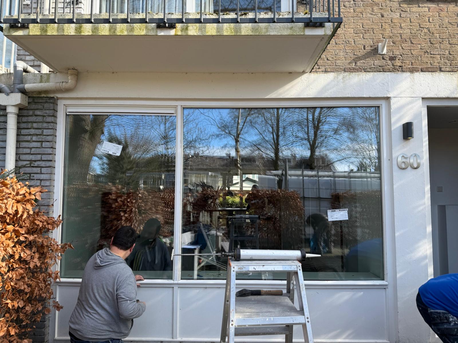 Kozijnen vervangen Hoofddorp tijdens montage van groot raam in bestaande gevel met vakman aan het werk