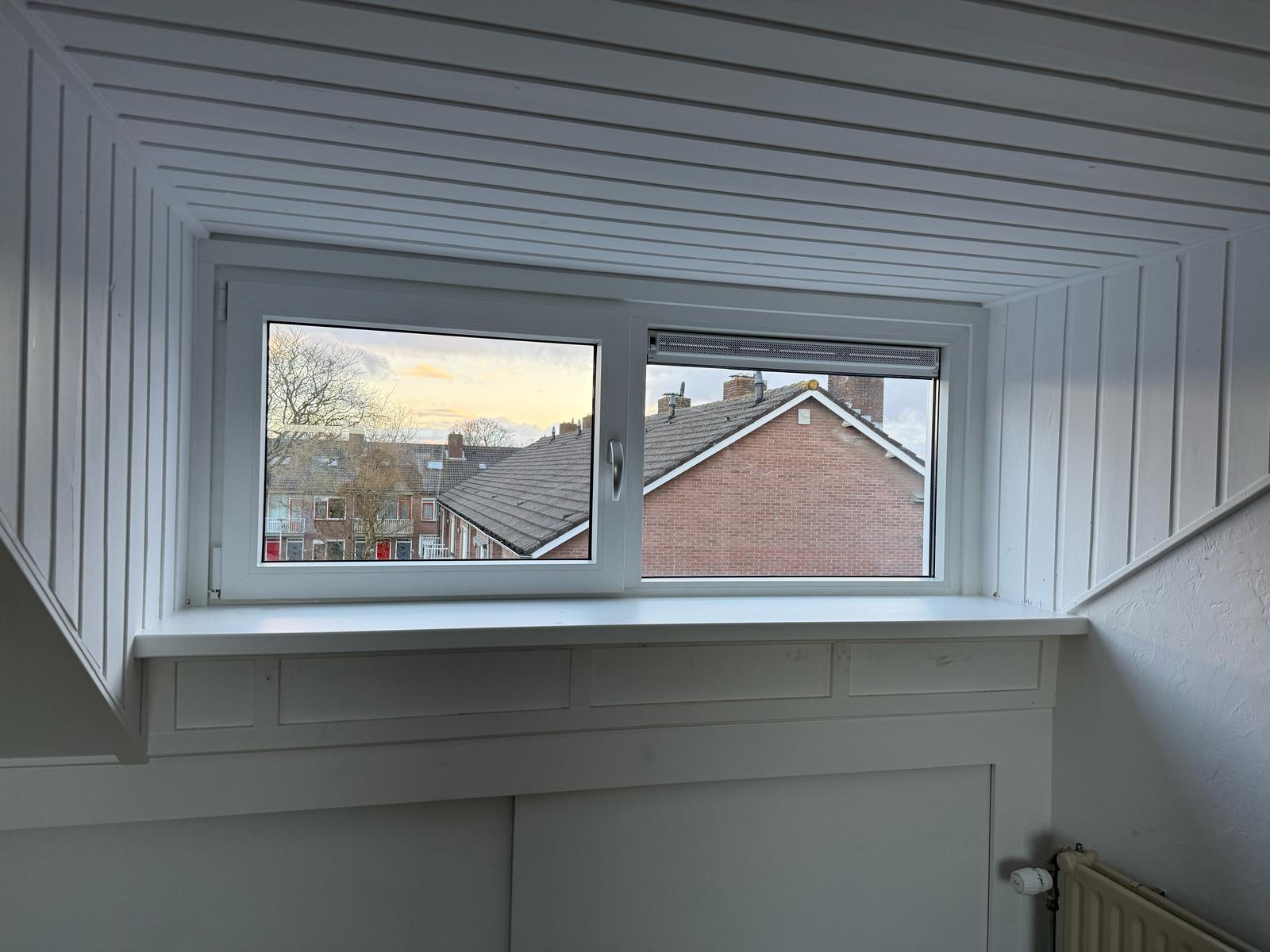 Kunststof kozijnen Hoofddorp geplaatst in dakkapel tijdens montage op schuin dak met zonnepanelen