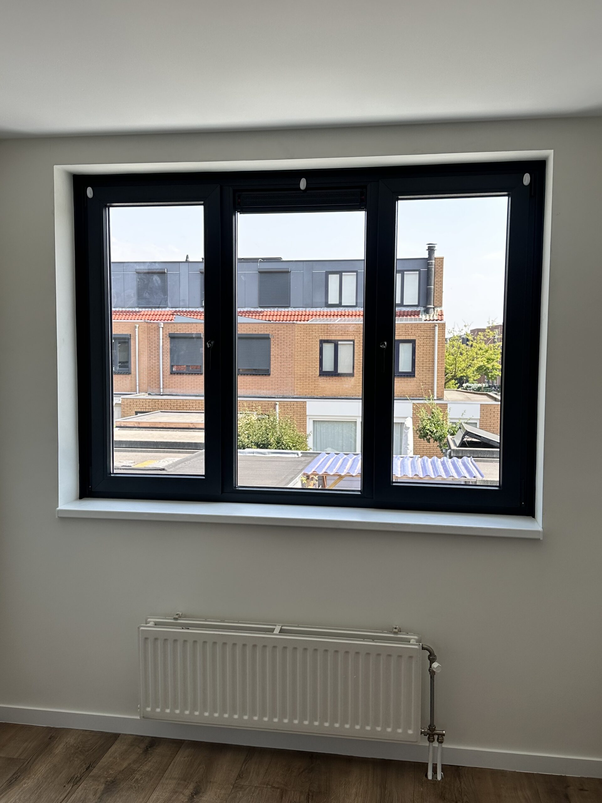Kunststof kozijnen IJmuiden zwart profiel binnenaanzicht met uitzicht op woonwijk