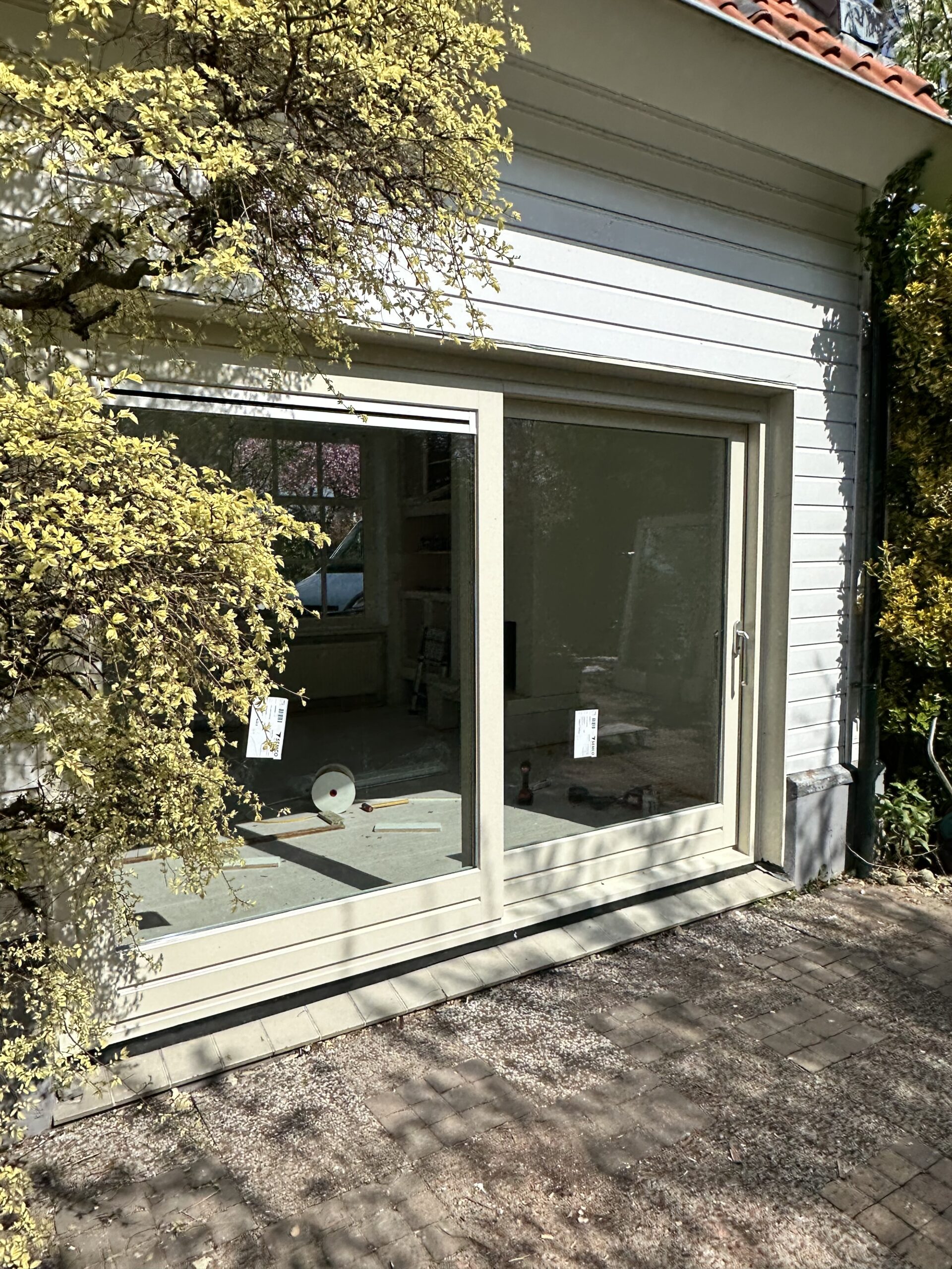 Kunststof schuifpui Halfweg met gevelbekleding geplaatst bij woningrenovatie