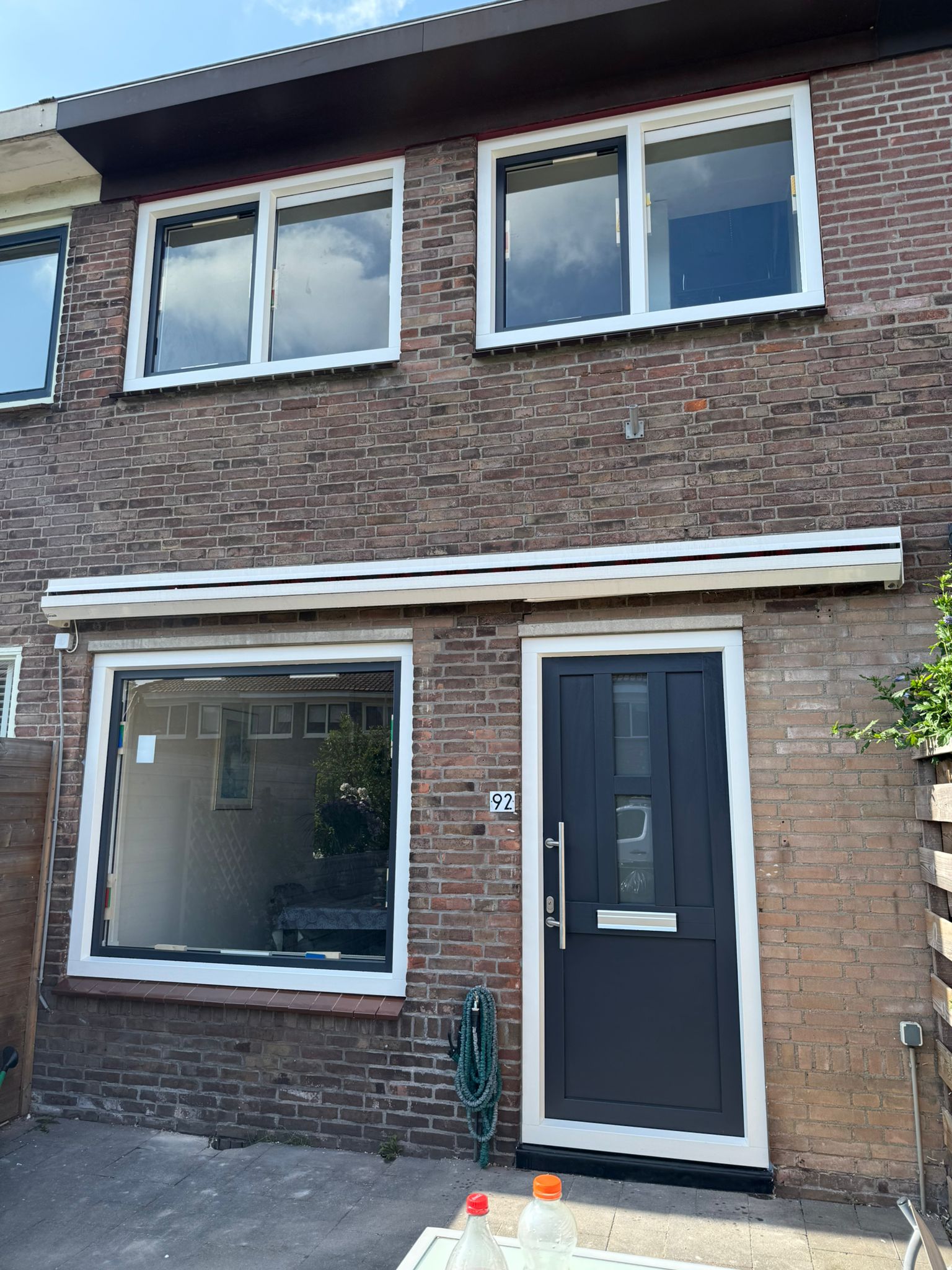 Volledig vernieuwde gevel met witte kunststof kozijnen en antraciet kunststof voordeur op woning in Heemstede, opgeleverd door KozijnBase