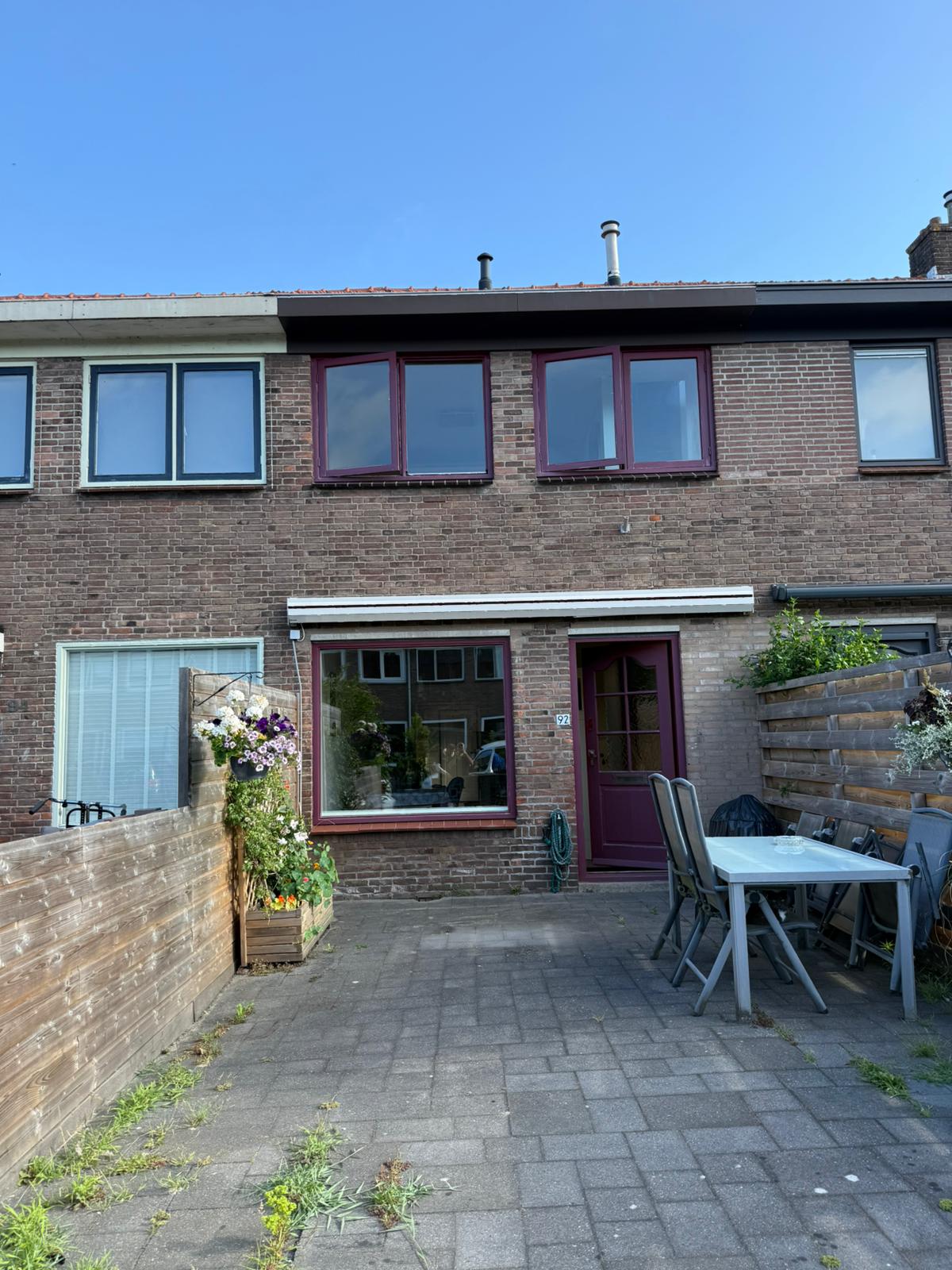 Voorgevel woning Heemstede vóór renovatie, bordeauxrode kozijnen en houten voordeur die vervangen worden door KozijnBase