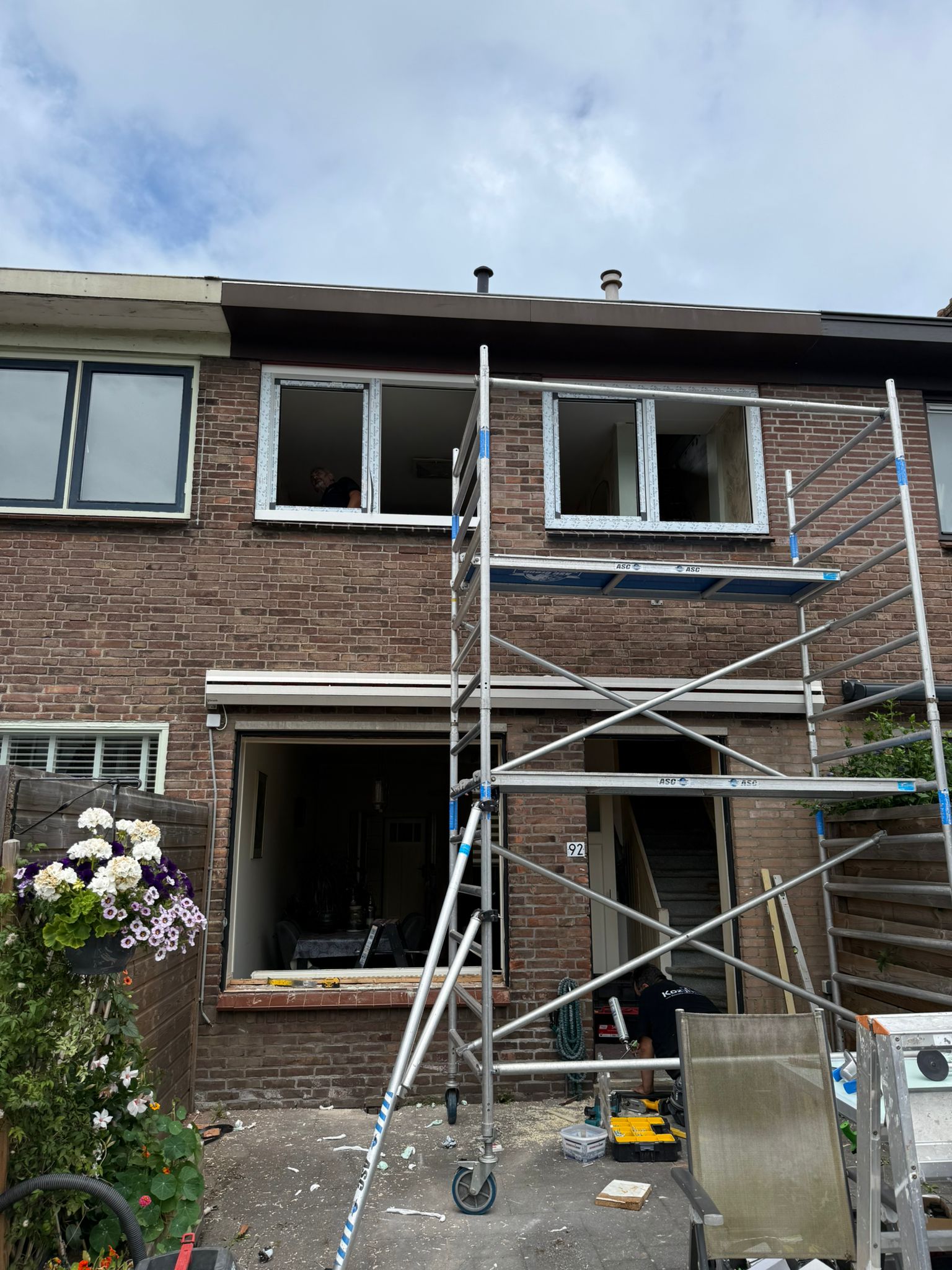 Werkoverzicht kozijnen vervangen Heemstede, steigers voor gevel, monteur bezig met plaatsen nieuwe kunststof kozijnen op de verdieping
