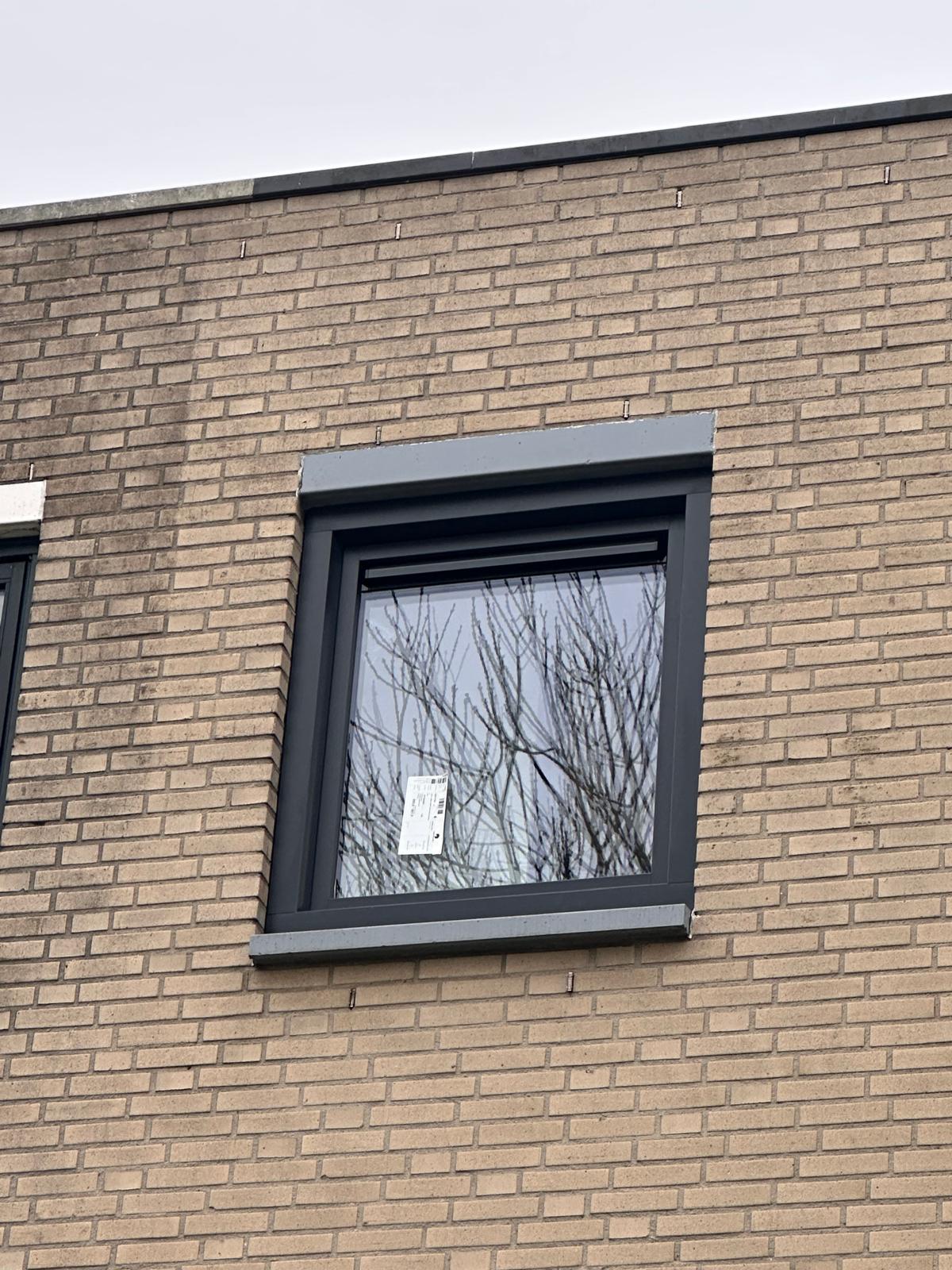 Antraciet aluminium kozijn met waterslag en strakke aansluiting op bakstenen gevel