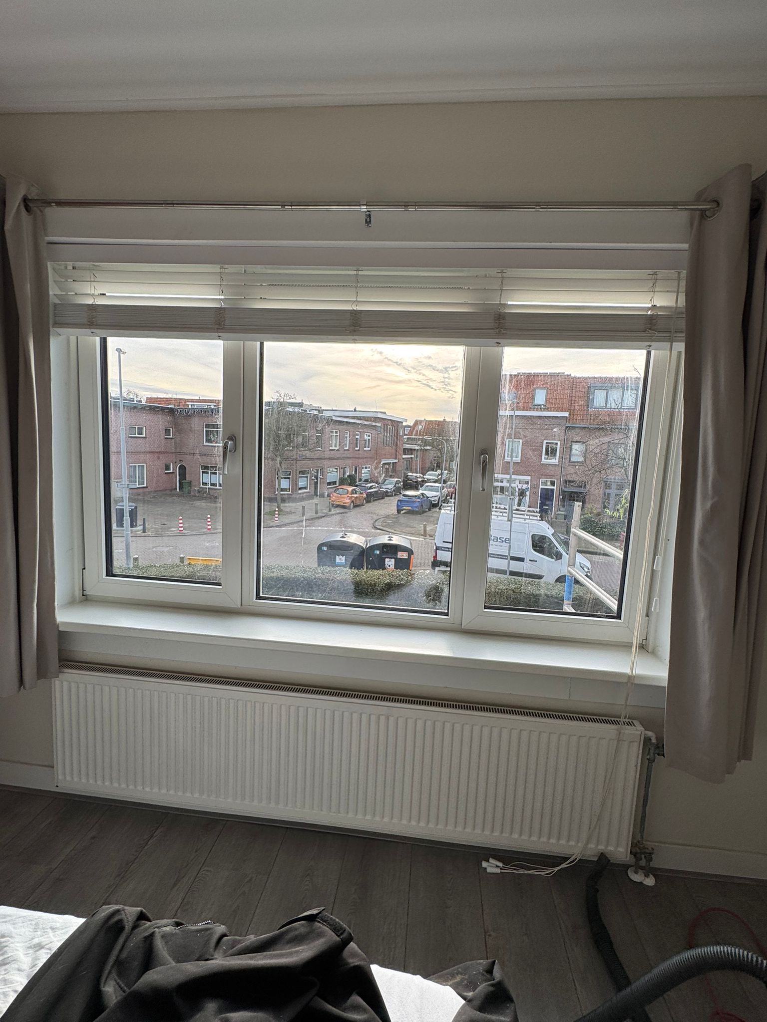 Binnenzijde slaapkamer met plisségordijn en gordijnen bij kunststof kozijnen