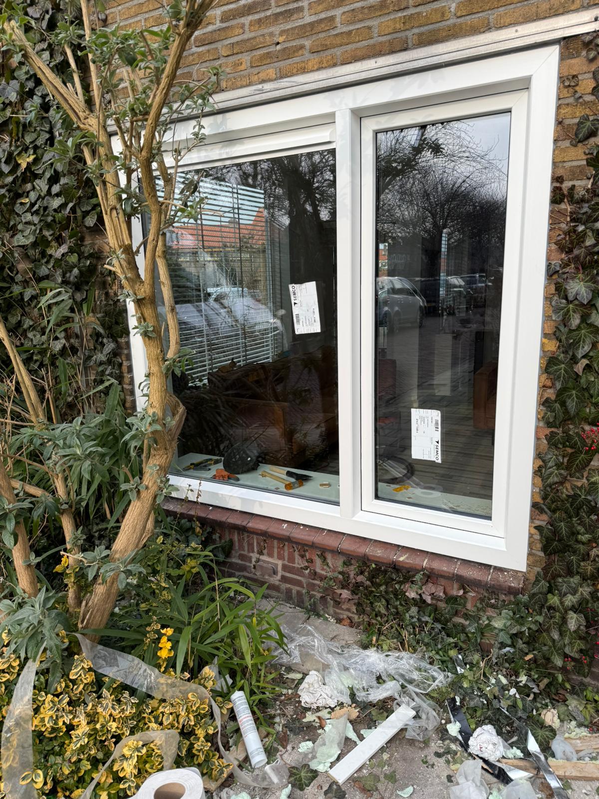 Buitenaanzicht van kunststof kozijnen tijdens montage bij renovatie van woning