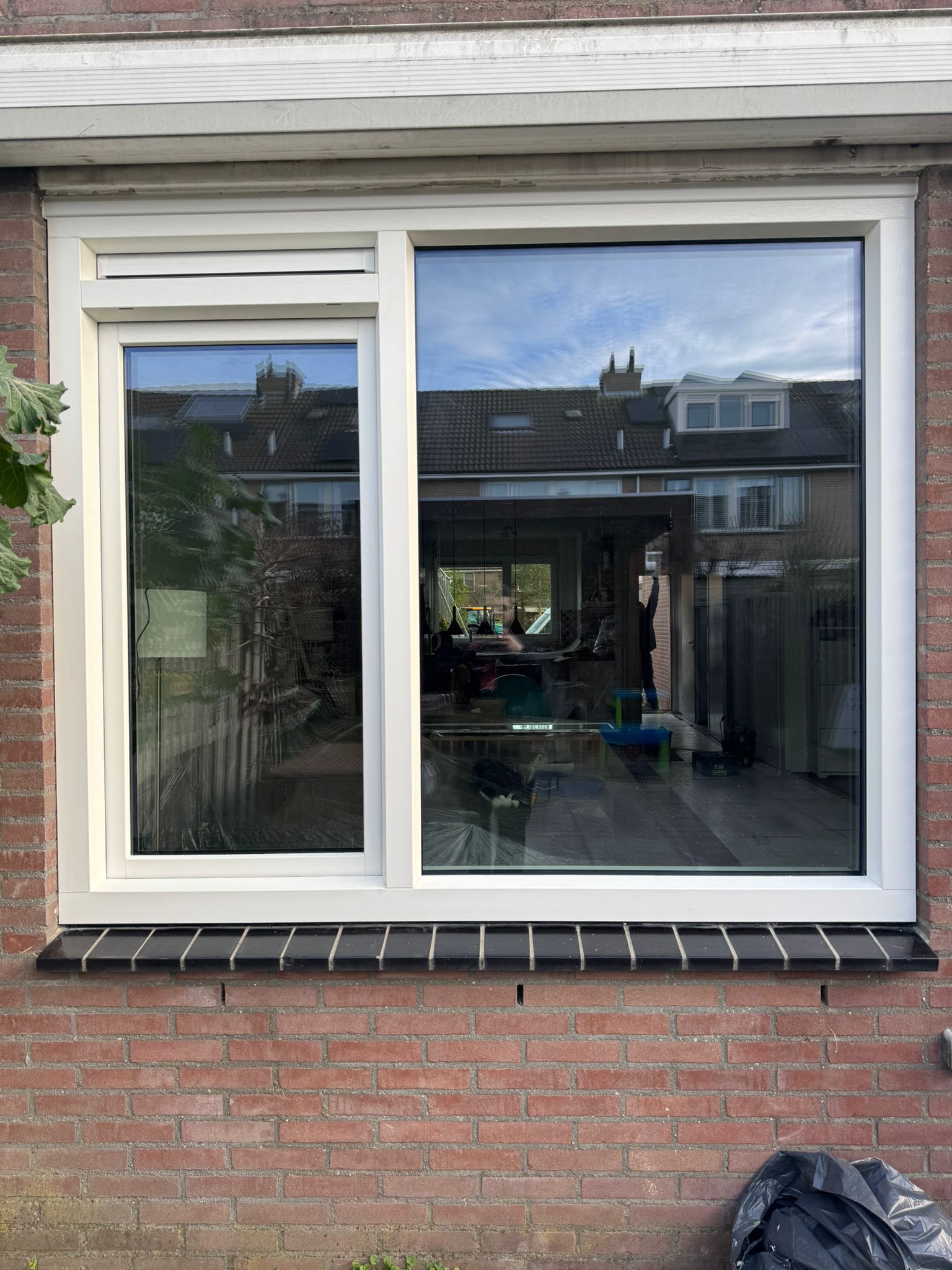 Kunststof kozijn met zwarte waterslag en dorpel onder raam in gemetselde gevel