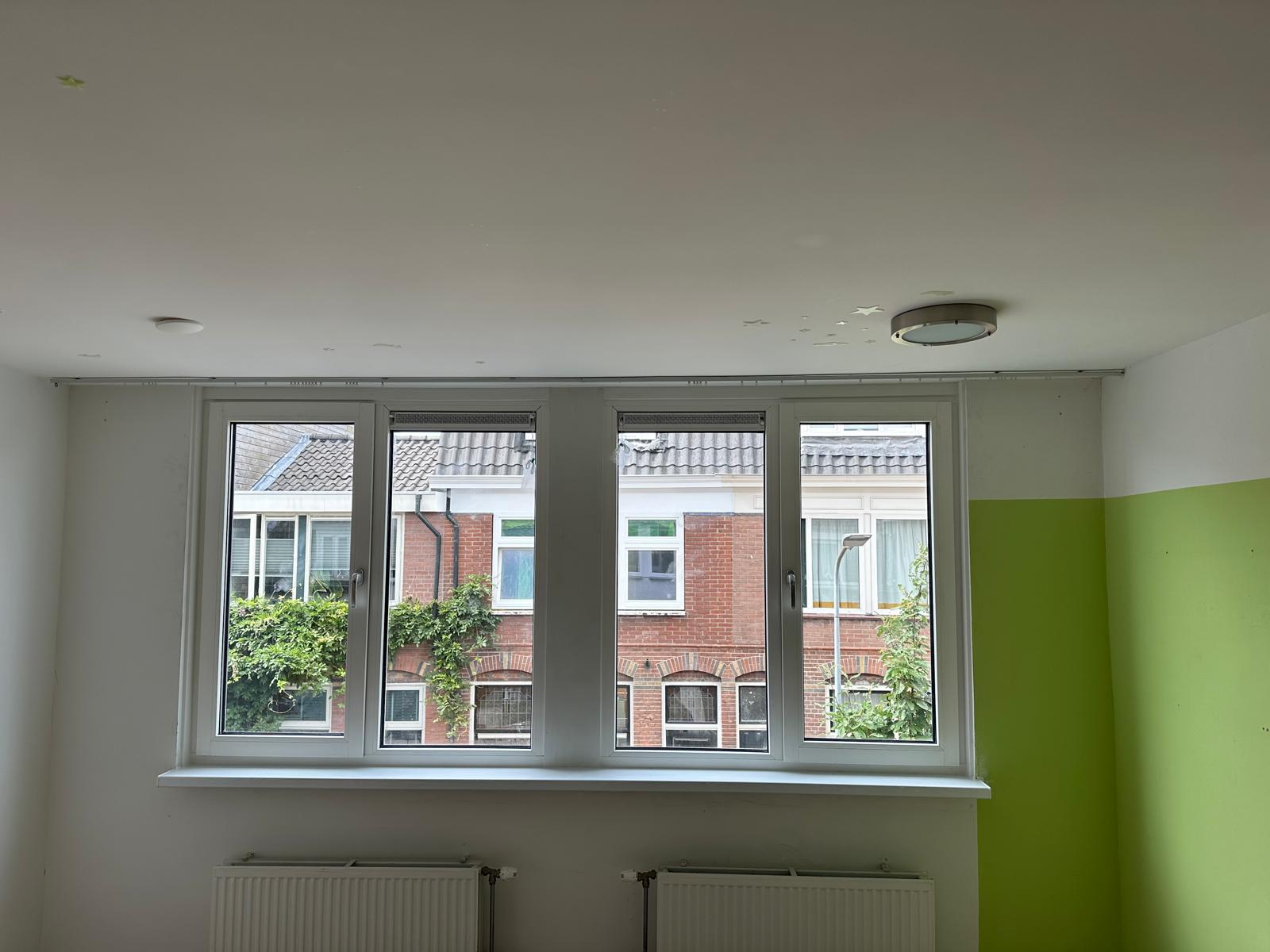 Kunststof kozijnen met ventilatieroosters geplaatst in gerenoveerde slaapkamer van woning