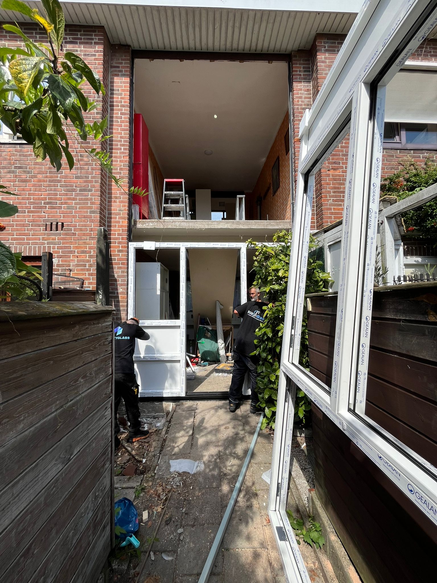 Kunststof kozijnen plaatsen tijdens renovatie in achtertuin woning met open gevel