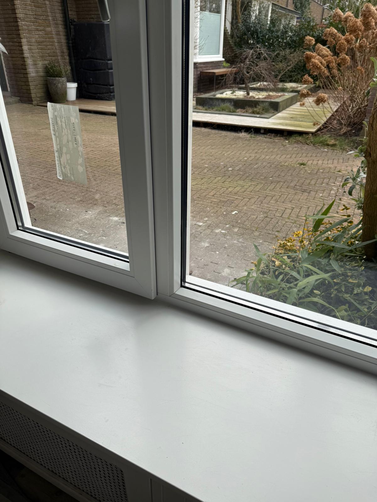 Nieuw kunststof kozijn met HR++ glas en witte vensterbank geplaatst in woning