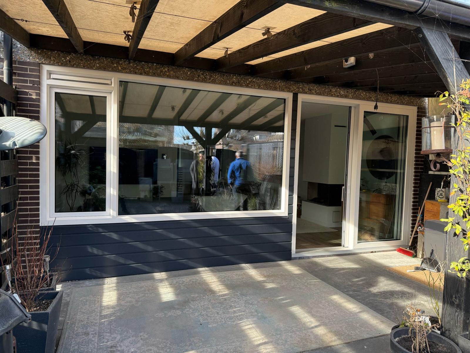 Afgewerkte houten schuifpui met grote glaspartij aan achterzijde woning