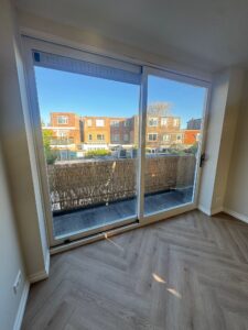 Aluminium schuifpui met grote glaspartij en uitzicht op balkon