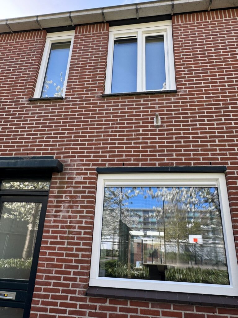 Complete voorgevel na plaatsing van nieuwe kunststof kozijnen en isolerende beglazing