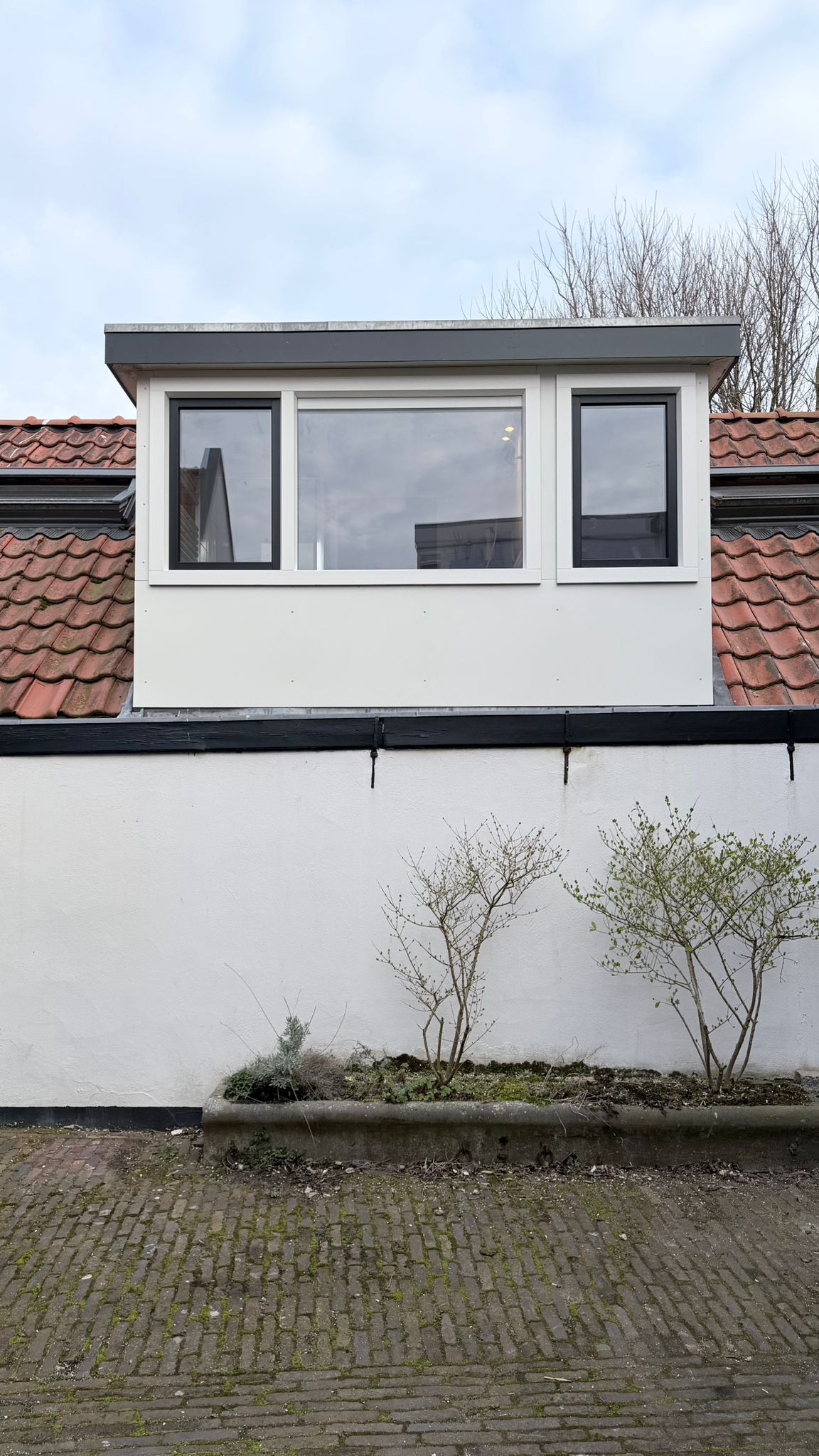 Gerenoveerde dakkapel met nieuwe kunststof kozijnen en onderhoudsarme gevelbekleding.