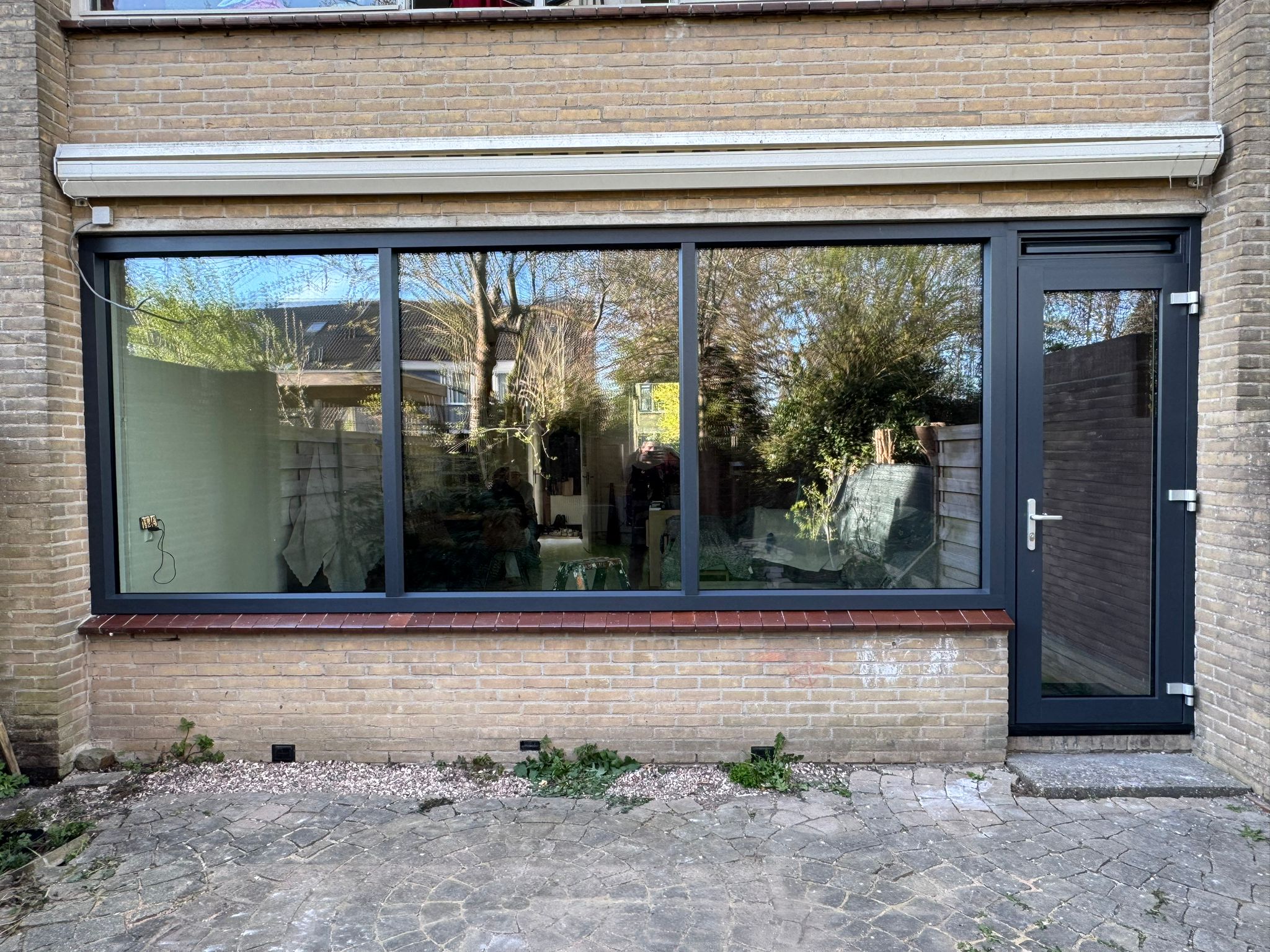 Kunststof achterpui met vaste glasdelen en antracietkleurige tuindeur na renovatie