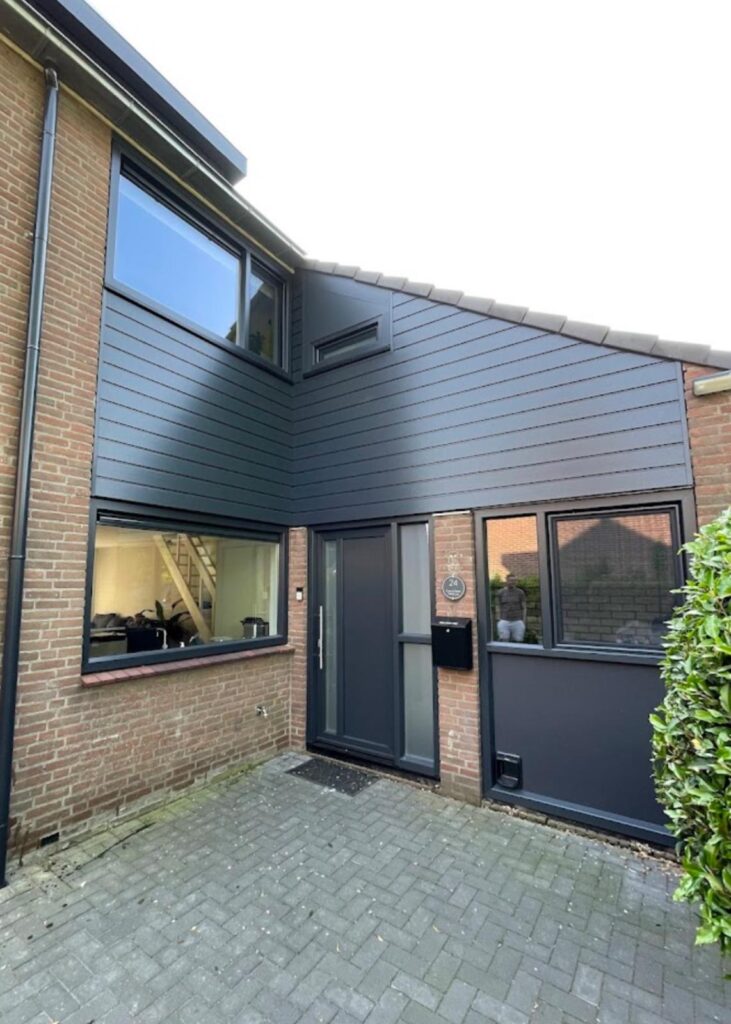 Kunststof gevelbekleding met houtnerfstructuur rondom entree van een woning