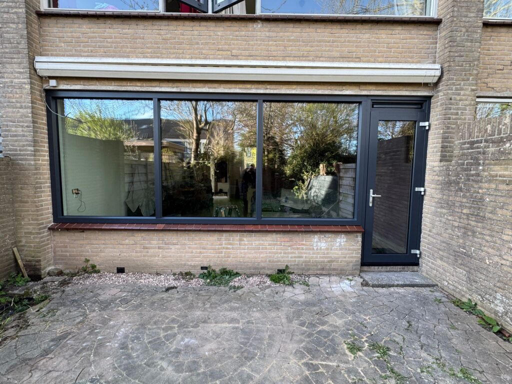 Moderne kunststof achterpui met HR++ glas en tuindeur aan de achtergevel