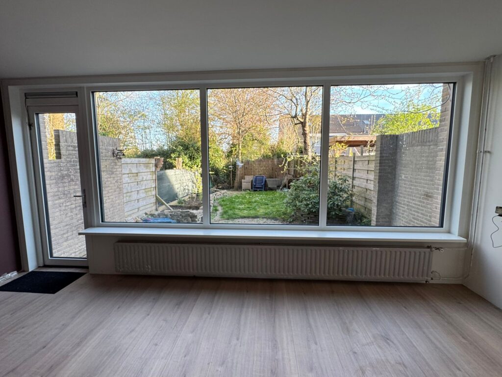 Nieuwe kunststof achterpui met grote glasvlakken en uitzicht op de tuin