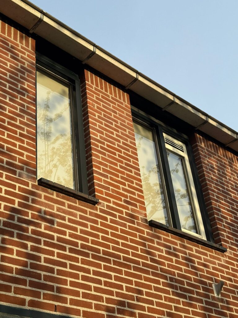 Oude kozijnen op de eerste verdieping vóór vervanging door kunststof kozijnen