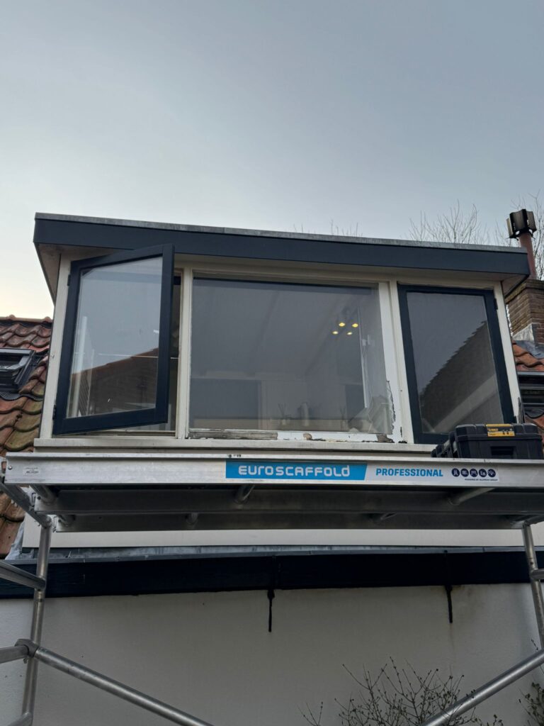 Verouderde dakkapel met oude kozijnen vóór de renovatie.